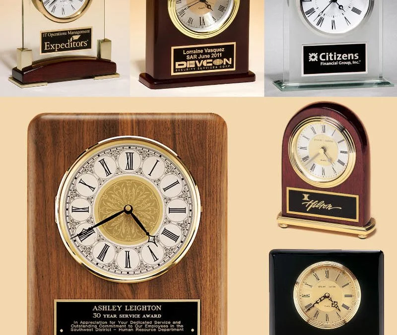 Six engraved clocks with award-winning designs, featuring wood and metal elements, each showcasing elegant corporate recognition.